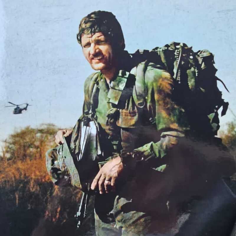 Mike West with helicopter behind him